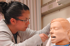 Adriana Duenas, nursing major, practices inserting and removing nasal gastric tubingbing.