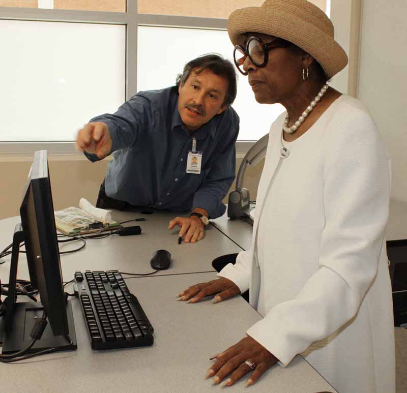 Sal Valencia, Multimedia Support Technician, shows Maria A. Brown, history professor, something on her computer in her new classroom in the recently renovated Social Science Building.