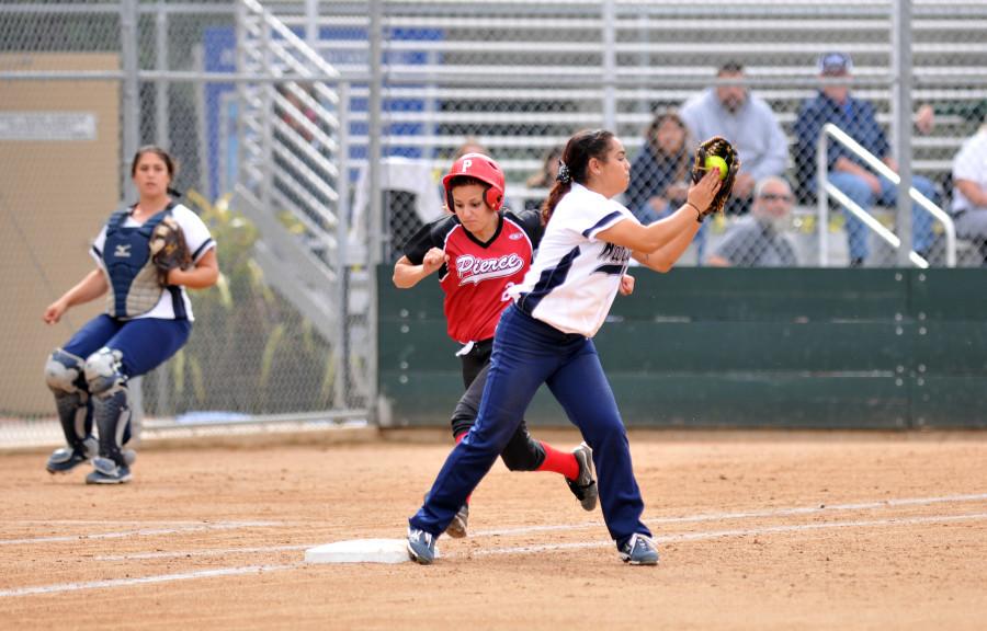 At the top of the first inning, Reina Trejo on first base, gets a Pierce player out. The Warriors swept the  Brahmas 11-0 on Friday Feb. 27. Photo credit: Amira Petrus