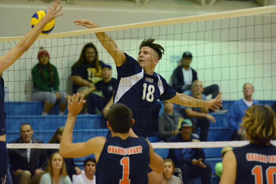 EC Outside hitter, Casey Wood, hits a ball down against an OC defender. Photo credit: John Fordiani