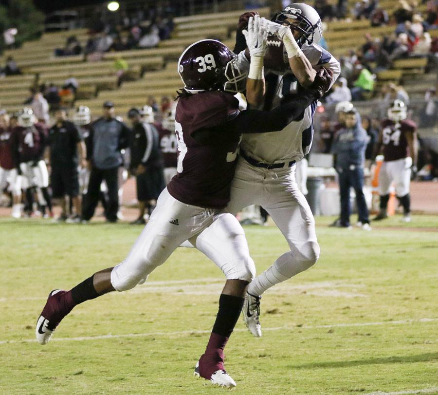 Freshman Isaac Cox catches the ball in the end zone while battling against Mt. SAC player Casey Gayle. The Warriors lost 26-13 against Mt. SAC on Saturday night. Photo credit: Jorge Villa