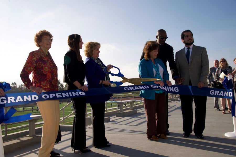 President Dena Maloney is preparing to cut the ribbon, while the El Camino Board of Trustees looks on.  From left to right: Dr. Virginia Pfiffner, Nicole Mardesich, El Camino Board of Trustees Student Member, El Camino President Dena Maloney, Mary E. Combs El Camino Board of Trustees Member, Kenneth Brown, El Camino Board of Trustees President, and John Vargas, Vice President of the Board of Trustees at El Camino. Photo credit: Marlena Keenan