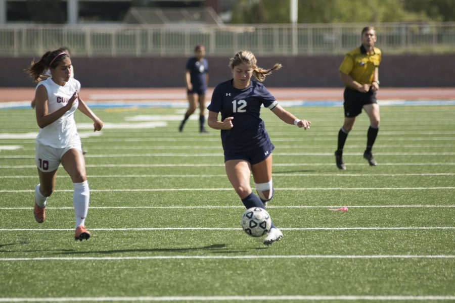 Kalyn Kaemerly (12) uses her speed to gain an advantage over defender, Angie Valle at Murdock Stadium. Photo credit: Elijah Hicks