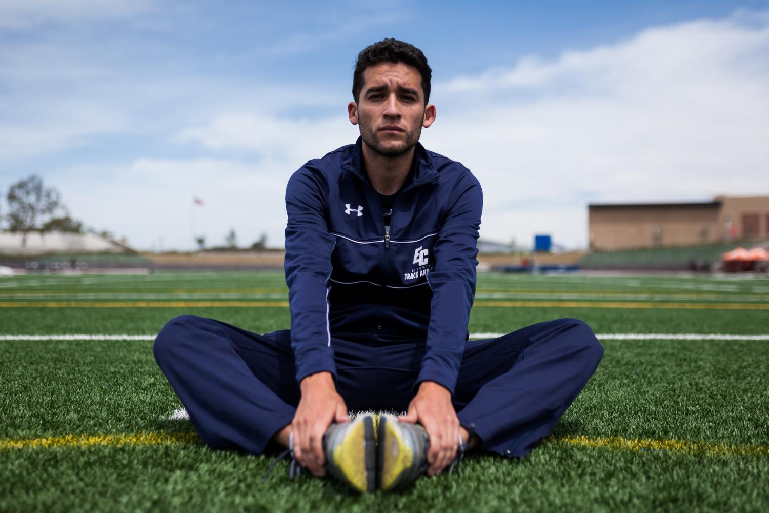 Israel Cardona, 21, business major crosses his legs and focuses before running on the track for the South Coast Conference preliminaries on Tuesday, April 25 at Murdock Stadium. Photo credit: John Lopez