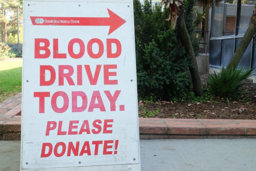 A sign indicating where the Cedars-Sinai blood drive is located, standing near the Student Activities Center. Photo credit: Emma Dimaggio