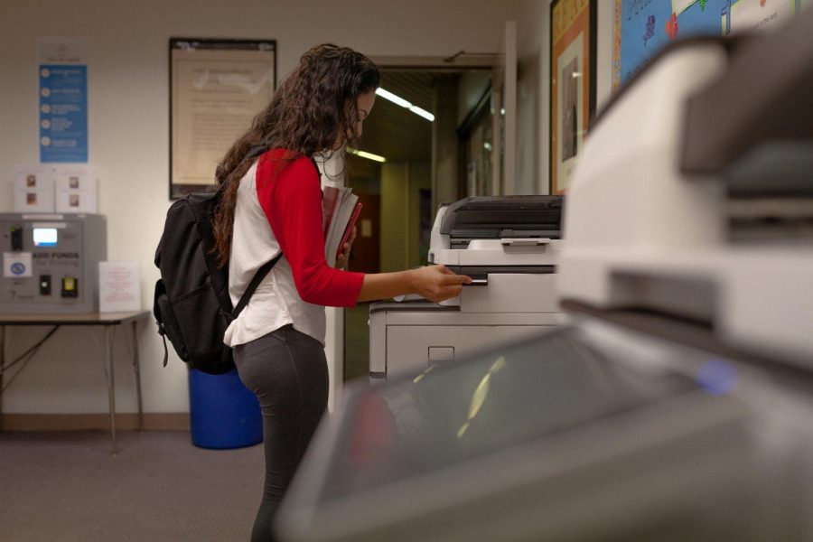 Liliana Garcia, 19, administration justice major is swiping her ECC ID on the newly installed copier system on the main floor of the Schauerman Library. Garcia is printing a test she recieved via email from her professor.