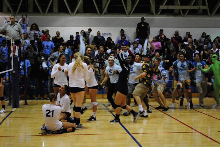 Jaylin Motley (No. 21) falls to the ground with her teammate Aiko Waters as the Warriors celebrate the victory and the conference title, their 8th consecutive. Photo credit: Dmitri Hansen