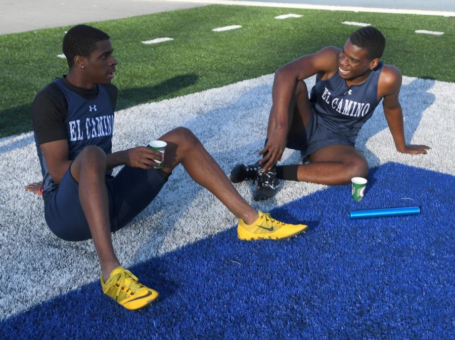 Two members of the 4X400m ECC relay team relax after their race. Photo credit: Jack Kan