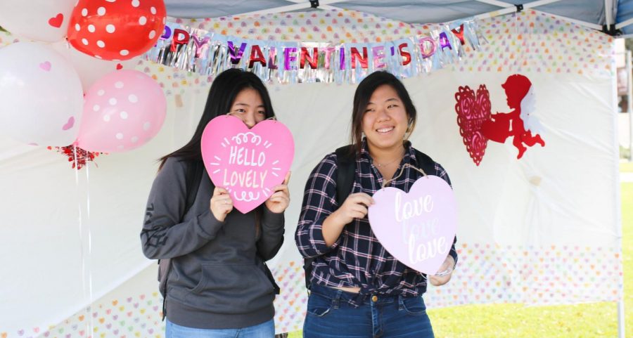 Students pose with props at the photo booth set up by the Financial Aid Office at the Fall in Love with Financial Aid fair on Tuesday, Feb. 13. Photo credit: Emma DiMaggio
