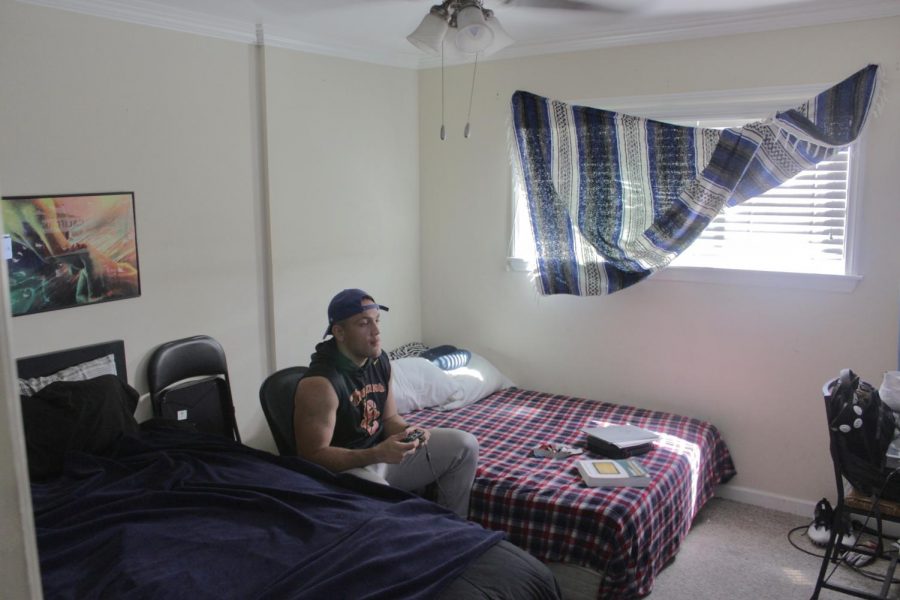 Jaymin Austin, 21 relaxes in his room playing a few rounds of Fortnite. Photo credit: Jeremy Taylor