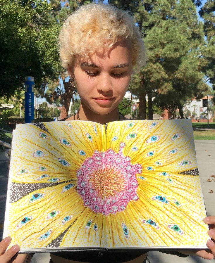 Multi-talented artist, Jackie Robinson, shows off one of her drawings by the art quad on Tuesday, Nov. 9. Photo credit: Arielle Chacon