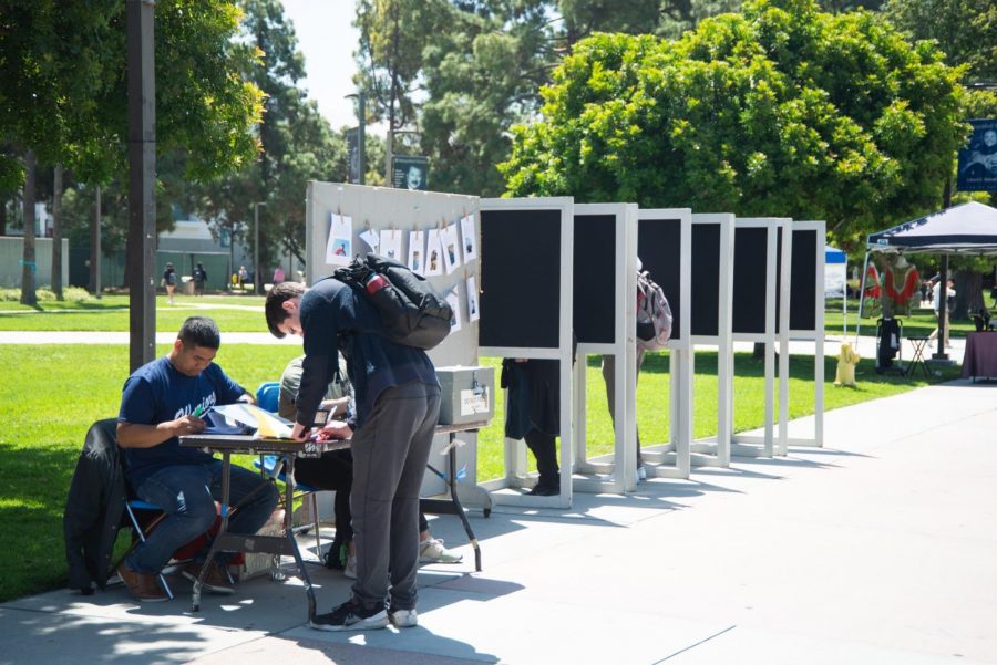 A student signs up to vote next to booths containing two voters on Wednesday, May 29. The results will be announced Friday, May 31. Photo credit: Jun Ueda