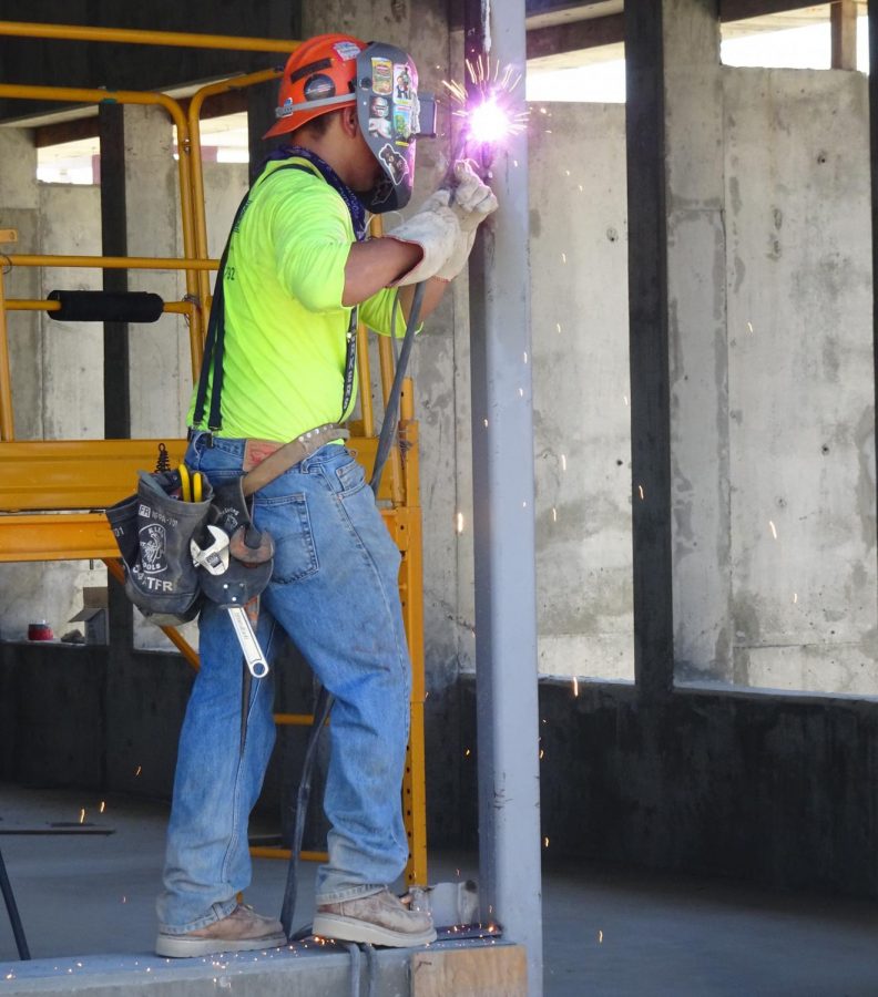 A construction worker welds a metal beam at the Pool and Classroom Building construction site Thursday, Aug. 29. Welding was the cause of a small fire on the buildings second floor on the second day of the fall semester. Ryan Farrell/The Union