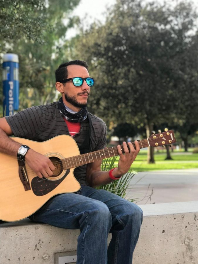 Michael Nicoli Ferrey, 32, music major, plays his guitar at his regular spot between the MBA and Music Buildings at ECC on Oct. 14. Nicoli is a multi-musician who also plays the piano, drums and bass. “Currently my goals consist of recording my music successfully finally because it’s been a long process that I haven’t accomplished yet,” Nicoli said.