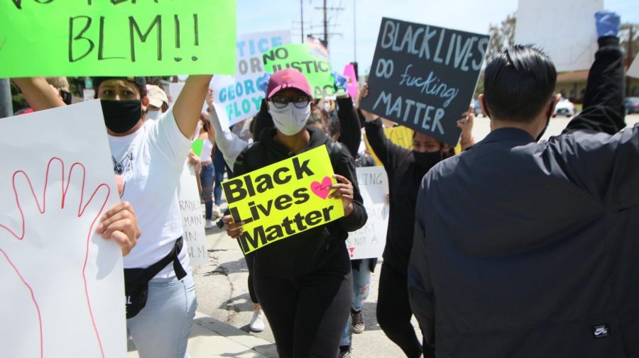 A protester holds up a Black Lives Matter poster as she strides through a crosswalk on Madrona Avenue. On Sunday, May 31, there were a series of protests in response to the death of George Floyd. This demonstration occurred at Torrance Boulevard and Madrona Avenue at 1 p.m., near Torrance City Hall. Molly Cochran/The Union