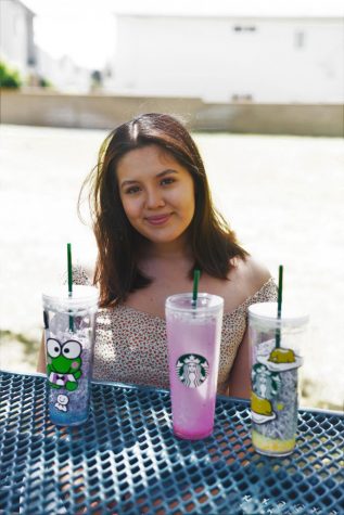 Michelle Mondragon poses, smiling, next to some of her most recent orders that have been finished. Each cup order goes for about fifty dollars. Image taken on May 2. (Francisco De La Cruz/ The Union)