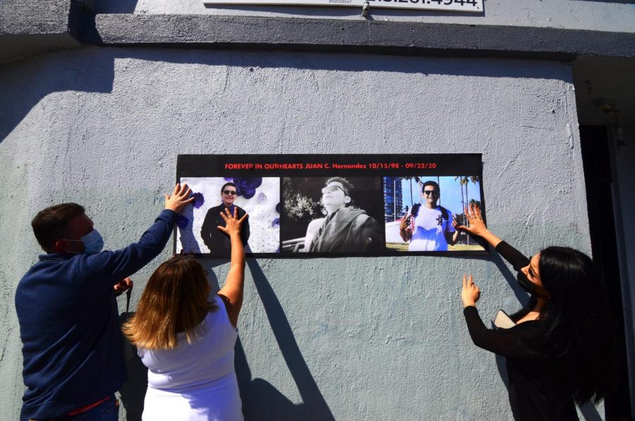 Members and friends of the Hernandez family prepare to tape a printed poster with three images of Juan Carlos Hernandez over the wall outside the dispensary where he worked and was allegedly murdered by suspects Ethan Kedar Astaphan, Sonita Heng and Weijia Peng on Sept. 22, 2020. The case is ongoing. Astaphan and Hang were eventually captured and arrested last November. Peng is currently in custody in Turkey where he is attempting to fight his extradition to the United States. "All year I wanted to go back to the last place [Juan] took his last breath," Juan Hernandez&squot;s mother, Yajaira Hernandez, said. "That place was where we wanted to do a small vigil and pray for Juan&squot;s soul."