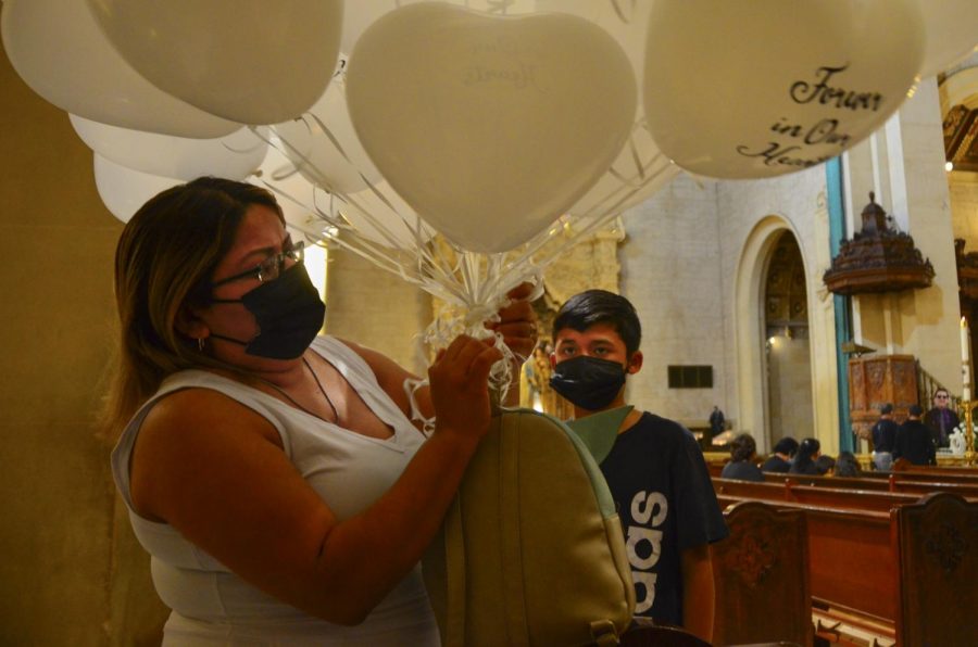 Juan Carlos Hernandez&squot;s aunt, Stephanie Pineda, left, prepares a set of balloons that read "Forever in Our Hearts" while her son, Nathan Melendez, 11, looks on during the Memorial Mass in Hernandez&squot;s honor on Wednesday, Sept. 22, 2021.