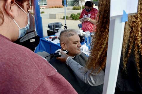 Christopher Xavier Lozano, 58, Army veteran, photographer and writer has his eyes examined through an autorefractive machine used to determine the correct lens prescription for a patient during a Veterans Day and Community Thanksgiving event on Wednesday, November 17 at El Camino College.  Over the course of his life, Xavier experienced homelessness as a veteran, worked as a photographer for years in and out of the military and as a studio makeup artist in the pornographic film industry and later in Hollywood where he worked on films such as 
