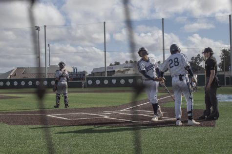 Warriors Ethan Felix(#15) and Dylan Knowles(#28) greeting each other after Felix scored the first run for the Warriors of the game. El Camino was defeated by LBCC 5-2 on Feb 22, 2022. ELCO will play against LBCC again on Feb 24, 2022 this time in Long Beach. Photo by Vitor Fernandez/The Union at El Camino College, Torrance, CA.