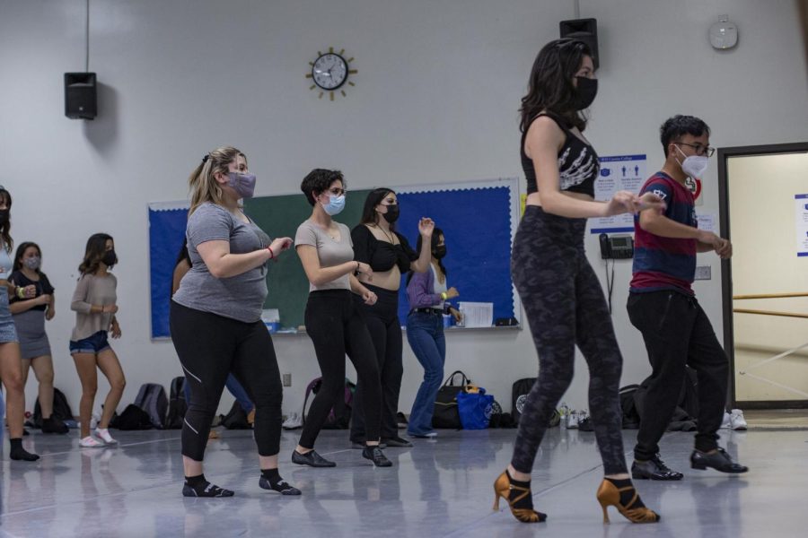 Alahna Alton, 17 ( front left), and Edrin Abrigo, 22 (front right), lead Salsa Club members in the correct way to step forward and step back during a Tuesday club meeting on March. 22. (Vitor Fernandez | The Union)