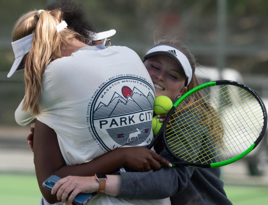 El Camino College Warriors Womens Tennis player Kayla Brown (left) is embraced by teammates Stefanie Liebich (middle) and Madeline Evans (right) following her game clinching win against College of the Desert Roadrunners Antonella Mazzotti at El Camino College on Tuesday, April 19. Browns win over Mazzotti would give the Warriors their first State Championship attendance in the programs history. (Naoki Gima | The Union )