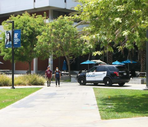 An El Camino College police car passes by as students walk across Library Lawn on Wednesday, May 25. This photo was taken one day after an 18-year-old gunman killed 19 children and two teachers at Robb Elementary School in Uvalde Texas. (Ethan Cohen | The Union)