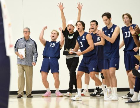 El Camino College men&squot;s volleyball Head Coach Richard "Dick" Blount remains stoic as the Warriors erupt with elation after a winning set vs. the Long Beach City College Vikings. The Warriors won the match 3-1 on March 11, 2022, in the ECC gymnasium. (Gary Kohatsu | Warrior Life)