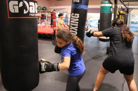 Abby Osorio, 9, (left), and Amy Plancarte, 11, (right), work the heavy bags at Sweet Science Boxing & MMA Gym in Hawthorne, Calif. on Thursday, April 7, 2022. Sweet Science offers young people a safe and nurturing space to train and compete. (Kim McGill | The Union)