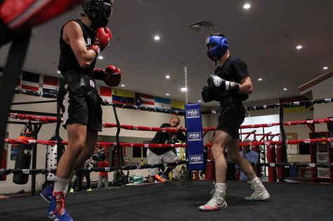 Coach Marco Trejo watches a sparring match between Joey Abudy (L) and Vlad Panin at Sweet Science Boxing & MMA Gym in Hawthorne, Calif. on Thursday, April 7, 2022. “I played a lot of sports, and I was good, but I felt that I didn’t reach my full potential as a youth,” Marco says. “I’m not afraid to say it, I had problems at home, drug problems, that kind of stuff. Once I got my head clear, as I got older, I thought I’d love to open a gym and give young people a chance to reach their full potential and not blow it like I did.” (Kim McGill | Warrior Life)