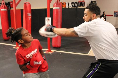 Coach John Hannah of Hawthorne trains a young boxer at Sweet Science Boxing & MMA Gym in Hawthorne, Calif. on Thursday, April 7, 2022. According to the gym’s owner, Marco Trejo, he opened the gym in 2009 to “give young people a chance to reach their full potential.” (Kim McGill | Warrior Life)