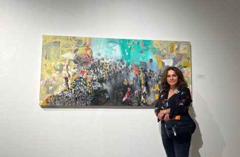 Artist and activist Fatemeh Burnes next to her painting entitled 'My Neighborhood' during the SOUNDS community opening on Sept. 10. Although her paintings don't make sounds themselves Burnes says she hopes her imagery inspire sounds from the the viewers. (Delfino Camacho | The Union)