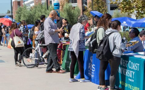 Students and employees walk around the Fall University Fair on the Student Services Plaza on Thursday, Sept. 22. Booths of more than 60 colleges and universities lined the plaza offering resources like transfer brochures and free commodities. (Ethan Cohen | The Union)