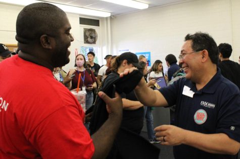 Vice President of Student Services Ross Miyashiro handed out tee shirts to people who attended the opening of El Camino College's new social justice center on Sept. 28 in Torrance, Calf.