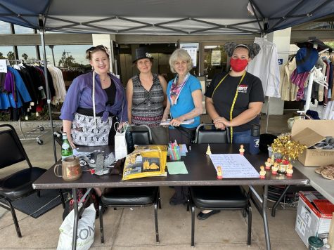 Kim Wilkinson (center right), costume shop manager, Kira Sherman (right), theatre technician, with other staff outside the Marsee Auditorium at the front desk of the Halloween Costume Sale, Thursday, Oct. 20, 2022.