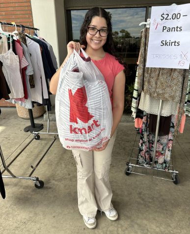 Leila Ramos, architecture major, outside the Marsee Auditorium with a bag of clothing that she bought at the Halloween Costume Sale, Thursday, Oct. 20, 2022.