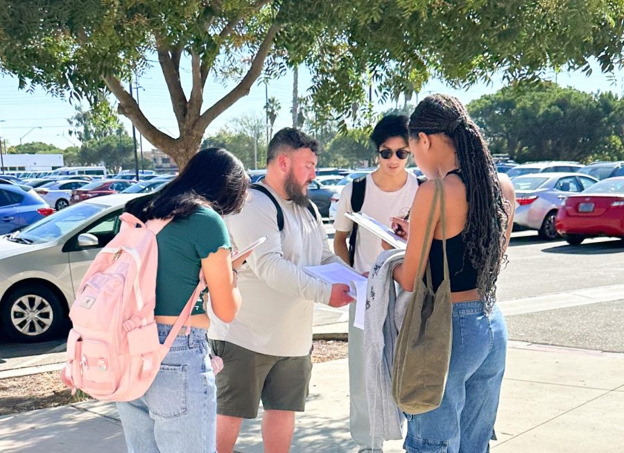 Adam Jaor obtains signatures from El Camino College students near parking lot J, on Wednesday, Oct. 19. Jaor, chief executive officer of Freeline Marketing and Consulting, said that he has six to seven petitioners who go around asking for signatures. (Eddy Cermeno | The Union)