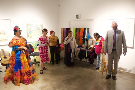 El Camino College Art Gallery Director and curator Michael Miller (far right) and student/organizer Dulce Stein (far left) welcome guest and introduce speaker Miriam Quezado-Hagerman (left, red and white dress) during the public reception of the 'Aqui y Alla y Mas' art exhbit. Quezado-Hagerman lecture on the history of the Mexican clothing item known as a rebozo is what kicked of the art event. (Delfino Camacho | The Union)