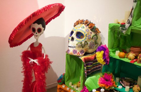Art pieces including skeleton woman and a decorative skull decorate the space around the ofrenda on display during the public reception for the 'Aqui y Alla y Mas' art exhibit held on Saturday, Oct. 15 in the El camino College Art Gallery . (Delfino Camacho | The Union)