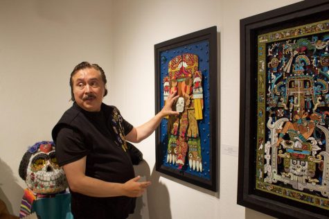 Artist Juan Varela discusses the importance of texture and color in his specific brand of embroidery focused art during the public reception for the "Aqui y Alla y Mas" art exhbit held on Saturday. Oct.15. (Delfino Camacho | The Union)