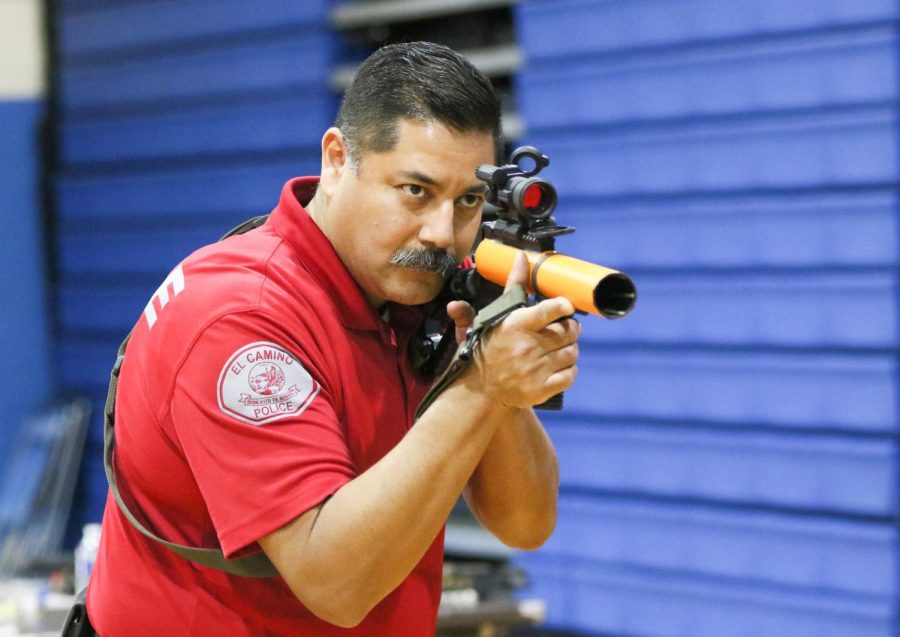 El Camino College senior rangemaster Francisco Esqueda aims one of the less lethal weapons at a dummy target at a weapons expo on Friday, Nov. 18. Esqueda has been a part of the department since 1996 and focused on highlighting each weapon and their capabilities. (Ethan Cohen | The Union)