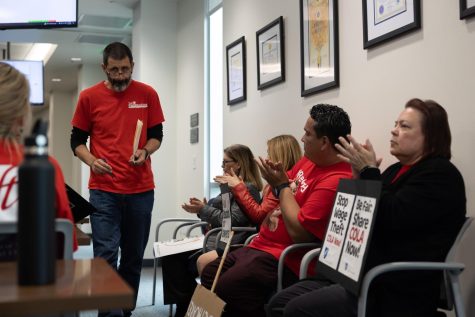 History professor John Baranski walks through a chorus of applause after speaking during the public comment section at the Board of Trustees meeting on March 20. Baranski said that negotiations regarding class sizes have been ongoing since May 2022. (Khoury Williams | The Union)