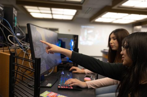 Studio Arts major, Diana Ojeda instructs her friend Vianka Smith through a match of "Call of Duty: Modern Warfare 2" at the Warrior Esports Center on Feb. 27. Ojeda said that she has her own PC gaming setup at home but enjoys going to the center to make friends and play games without pressure. (Khoury Williams | The Union)