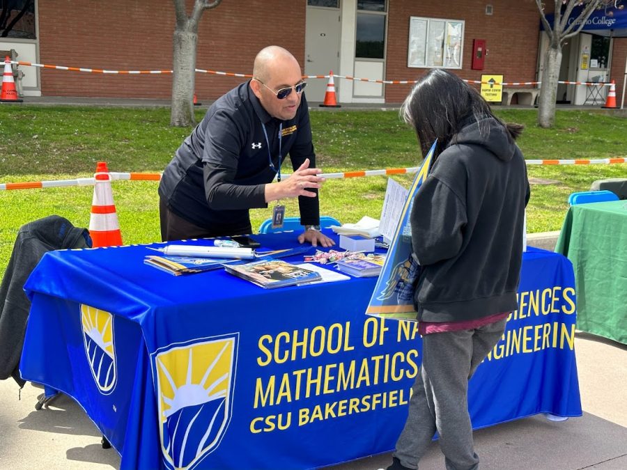 Natural sciences, mathematics and engineering Outreach and Community College Coordinator Abel Nunez-Guerrero speaks with a student at the CSU Bakersfield desk on Thursday, March 23. (Eddy Cermeno | The Union) Photo credit: Eddy Cermeno