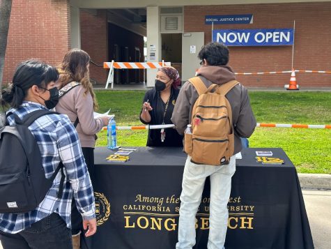 Erica Ifill-Dobbins speaking with Leslie Ortiz (left) and another student at the CSU Long Beach desk, Thursday, March 23.