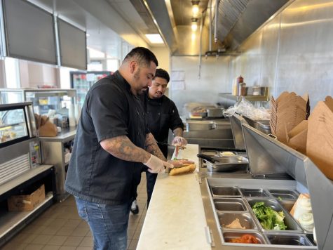 Pacific Dining Manager Mario Guerrero helps Kevin Solis prepare a sandwich at Café Camino to prepare lunch orders on Thursday, March 24.  (Nindiya Maheswari | The Union)