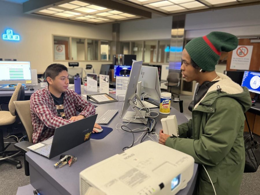 Computer Information System major Pablo Ortiz, 20, works at the Esports center inside Schauerman Library at El Camino College. Ortiz (left) chats with English Jennings (right), a student who comes to the center frequently on March 28. On the weekdays I work here [Esports Center], and on the weekends I work upstairs [Study Center], said Ortiz.  (Nindiya Maheswari | The Union) Photo credit: Nindiya A Maheswari Putri