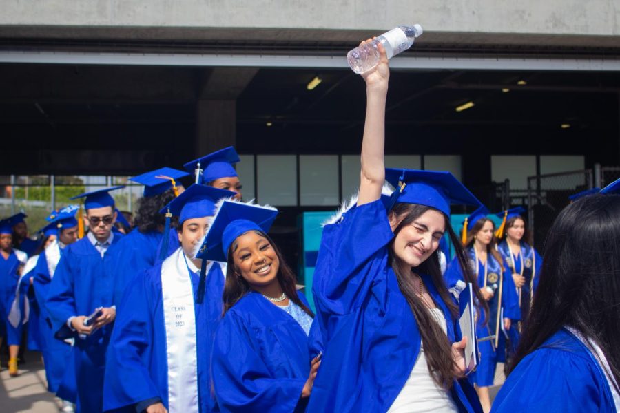 An El Camino College graduating student raises her fist triumphantly as she walks from the Murdock Stadium tunnel into the football field which is where the 2023 El Camino commencement ceremony took place on Friday, June 9. (Delfino Camacho | The Union)