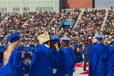 El Camino College graduating students donned in their traditional blue gowns and some with customized, decorated caps line up to receive their diploma as onlookers cheer in the stands during the 2023 commencement ceremony that took place June 9. Delfino Camacho | The Union
