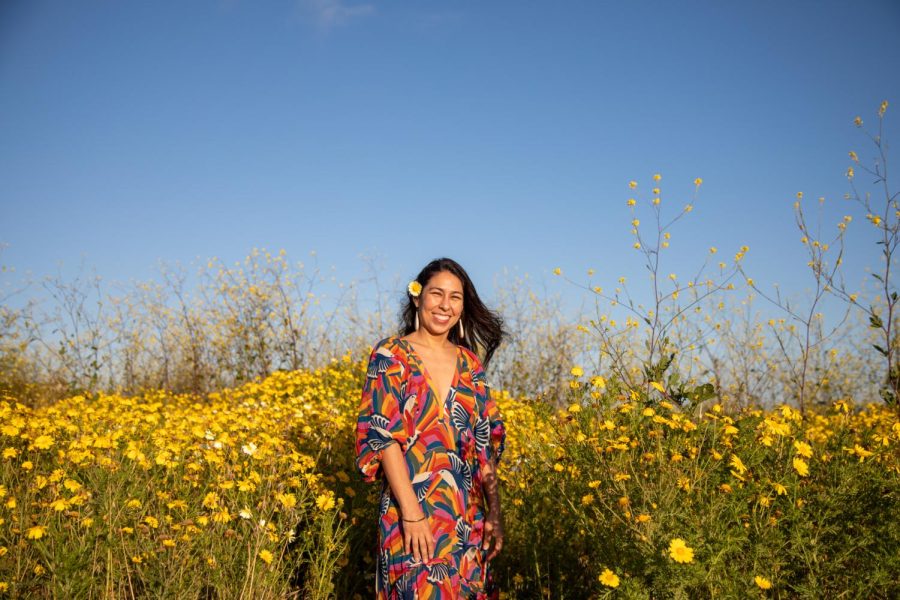 Monica Delgado poses in front of the yellow flowers near White Point Beach in San Pedro on Sunday, May 7. Delgado is the student success coordinator for the Social Justice Center at El Camino College. (Ash Hallas | Warrior Life)